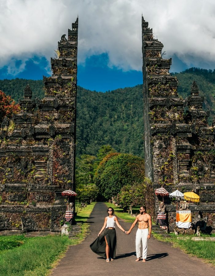 Beautiful couple at the Bali temple. Man and woman traveling in Indonesia. Couple at the Bali gate