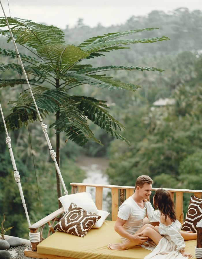 Couple sitting on a large swing on a Bali