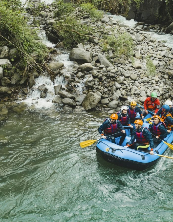 Group of people rafting in rubber dinghy on a river